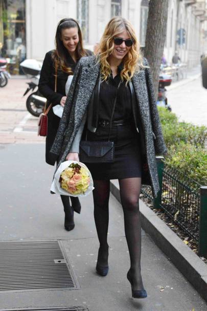 Barbara in minigonna nera e cappottino sulle spalle. In mano un bouquet di fiori (Olycom)